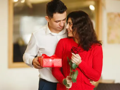 Couple exchanging a Valentine’s Day gift and red rose in Singapore
