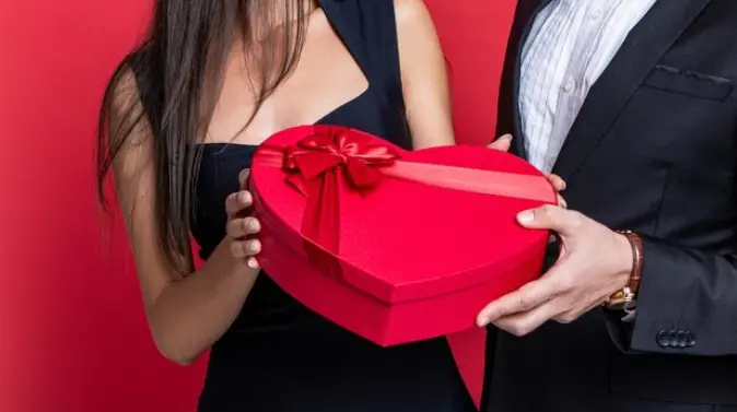 Heart shaped Valentine’s Day gift box held by a couple in Singapore